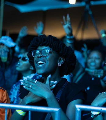 A smiling festival-goer clapping